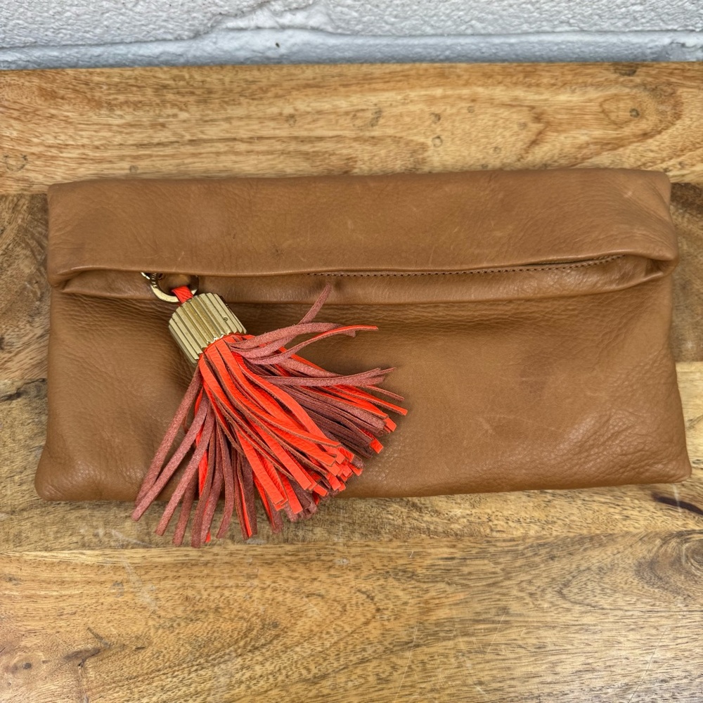 India Hicks “The Carmen” Leather Foldover Clutch | Brown w/ Coral Tassel